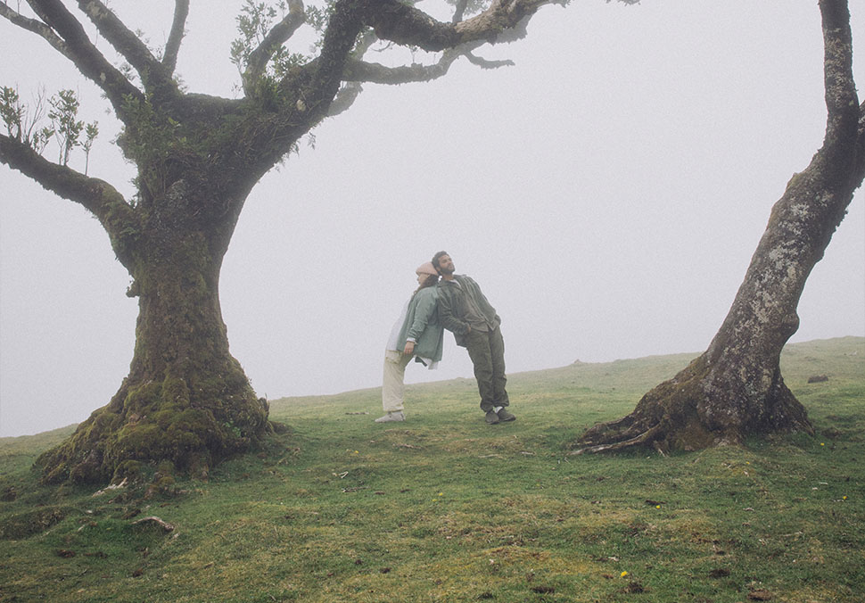 Two people, standing in the fog against each other, wearing Teva 'ReEmber' shoes.