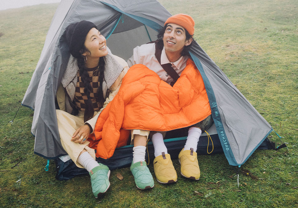 People sitting in a tent while wearing Teva 'ReEmber' shoes.