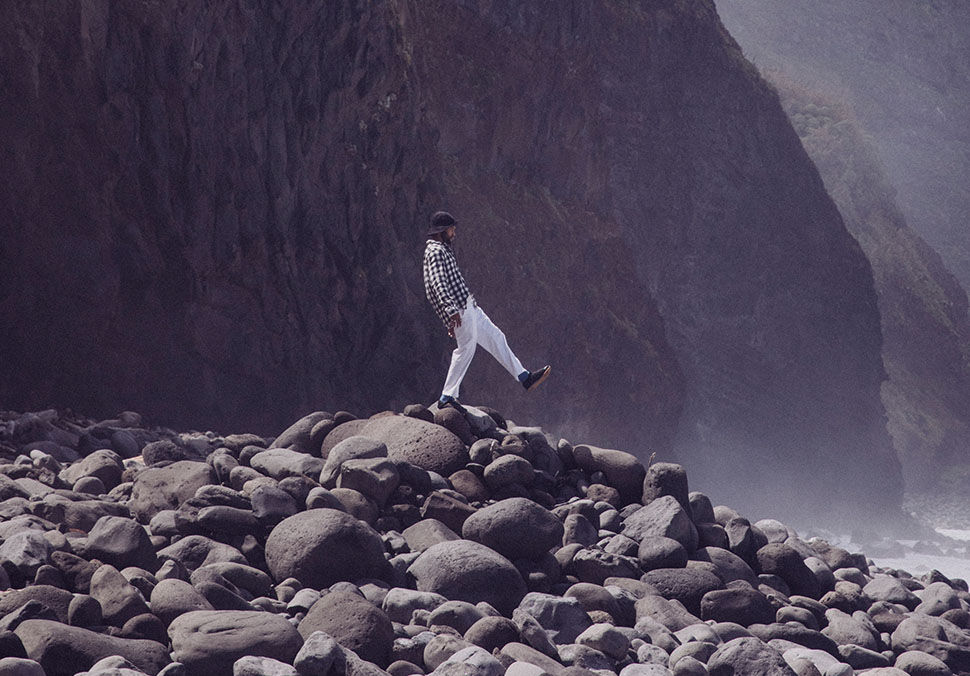 A person walking on the rocks, wearing Teva 'ReEmber' shoes.
