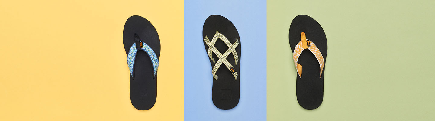 Teva flip flops on top of a colorful background.