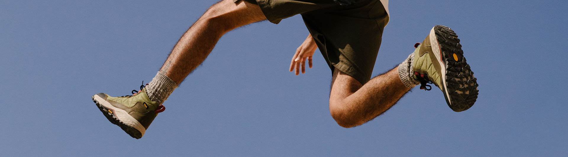 Person jumping while wearing Teva boots