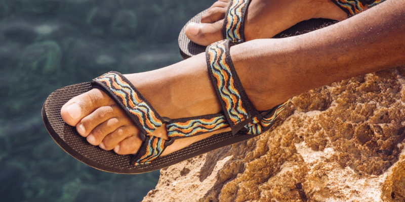 Close up of a persons's feet wearing Teva '80's Revive Collection' sandals.