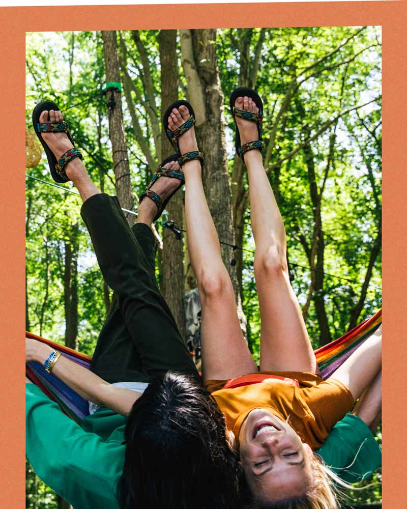 Aerial view of four different pairs of feet wearing Tevas, all standing in a circle