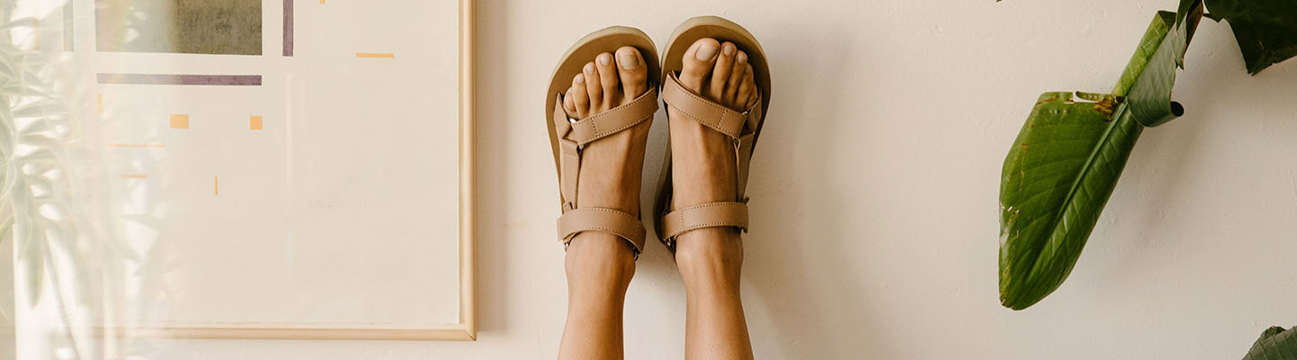 Close up of a woman's feet up in the air, wearing Teva sandals.