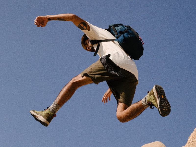 Person jumping while wearing Teva boots
