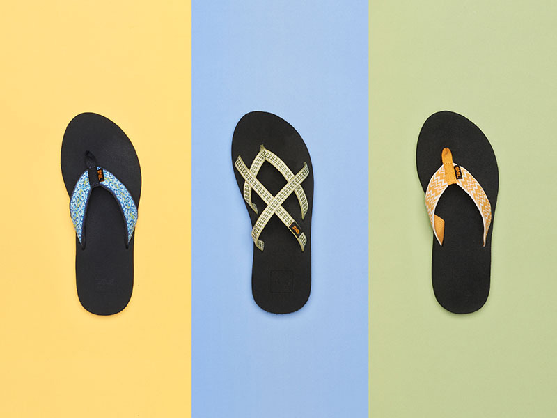Teva flip flops on top of a colorful background.