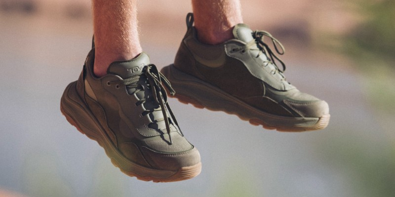 Close up of a person's suspended feet, wearing Teva boots.